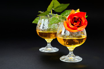 Two glasses of cognac with red rose