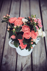 Bouquet of roses in vintage coffee pot