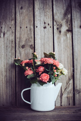 Fototapeta na wymiar Bouquet of roses in vintage coffee pot