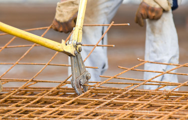Worker cutting reinforcement mesh