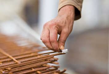 Worker measuring armature with tape