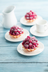 Raspberry tartlets with cream filling and dusted with icing sugar
