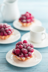 Raspberry tartlets with cream filling and dusted with icing sugar
