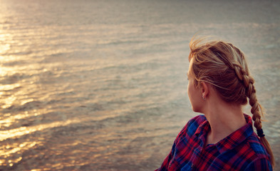young woman looking at sunset
