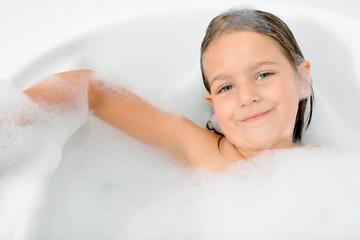 Adorable toddler girl relaxing in bathtub