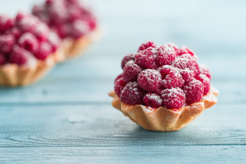 Raspberry tartlets with cream filling and dusted with icing sugar
