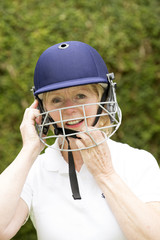 Portrait of an elderly woman cricketer wearing a batswomans' saftey helmet