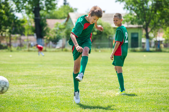 boys kicking football on the sports field