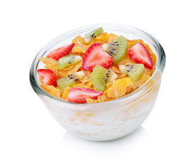 bowl of corn flakes with milk and fruit on white background.