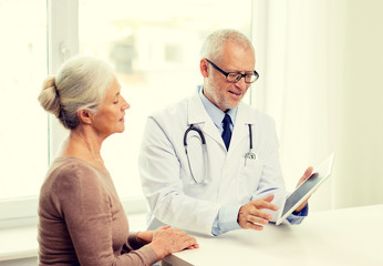 smiling senior woman and doctor with tablet pc