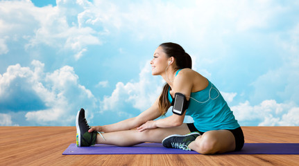 smiling woman stretching leg on mat over clouds