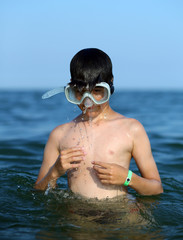 child swims in the sea with the diving mask in summer © ChiccoDodiFC