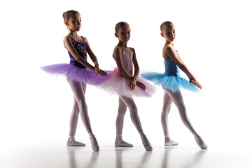 Three little ballerinas dancing in dance studio