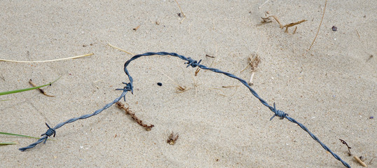 Fototapeta na wymiar barbed wire at the beach - danger