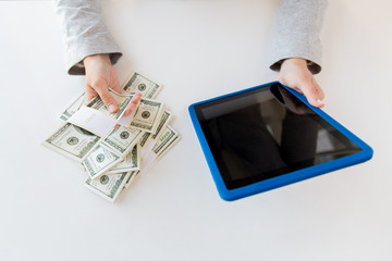close up of woman hands with tablet pc and money
