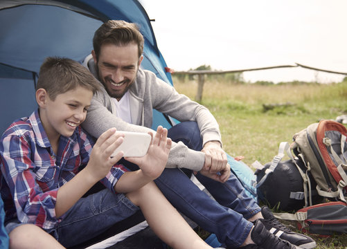 Boy using his smartphone on the camping