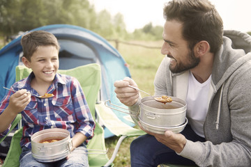 Father and his son eating dinner on camping
