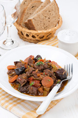 Stew with beef and vegetables on the plate, vertical