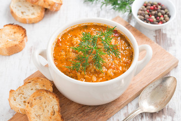 tomato soup with rice and vegetables in a white saucepan 