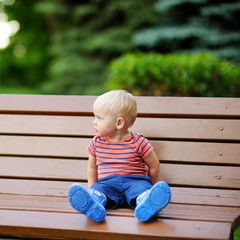 Toddler boy sitting on a bench