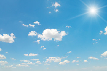 sun on blue sky with white clouds