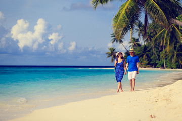 Obraz na płótnie Canvas happy loving couple walking on summer beach