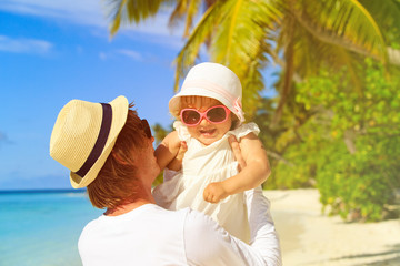 Happy father and cute little daughter at beach