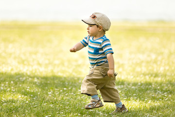 Kleiner Junge läuft schnell auf einer Wiese