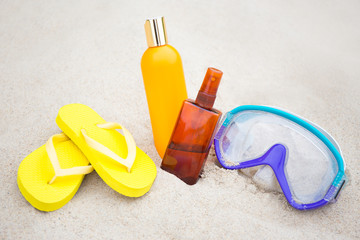 summer concept - flip flops, suntan lotion bottles and diving ma