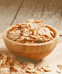 Whole grain wheat cereal for breakfast in a wooden bowl, selecti