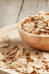 Whole grain wheat cereal for breakfast in a wooden bowl, selecti