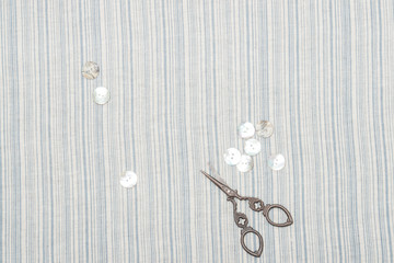 Pearl Buttons And Scissors On Natural Linen Striped Textile