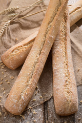 Three baguettes on the wooden background