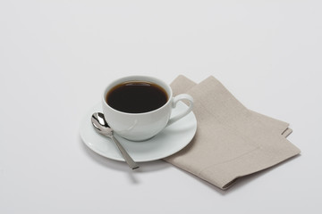 Black Coffee In White Cup On Folded Natural Linen Napkin. White