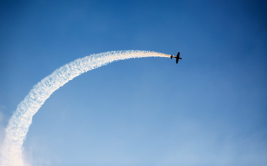Silhouette of an airplane performing flight at airshow - obrazy, fototapety, plakaty