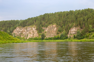 Fototapeta na wymiar Tourist route to the Urals. Ural rock view from the calm river