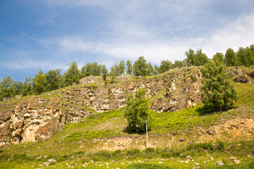 Fototapeta na wymiar Tourist route to the Urals. stone ridge, green field and blue sky
