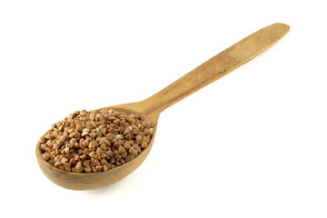 Uncooked buckwheat on wooden spoon