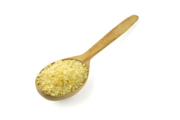 Raw and uncooked rice in wooden spoon 