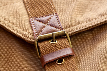 Buckle on canvas bag.
close-up of a buckle on a canvas bag.