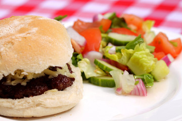 Burger with salad.
Beef burger with salad and onions on a plate.