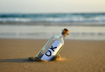 Bottle on the beach with an affirmative answer inside, ok