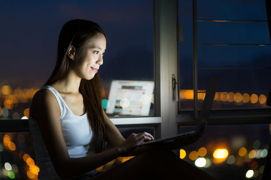Woman using notebook computer at night