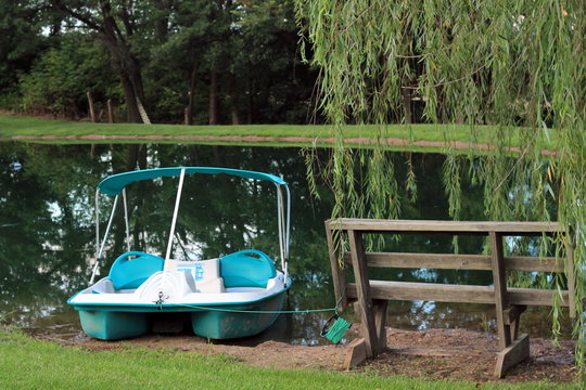 Pedal boat sitting on bank near bench