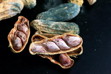 heap of moldy peanuts on a black background