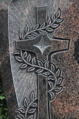 Steinkreuz mit Schlingpflanze und Strahlen auf einem Grabstein