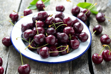 sweet cherry on a plate on wooden table