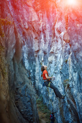 Rock climber climbing up a cliff