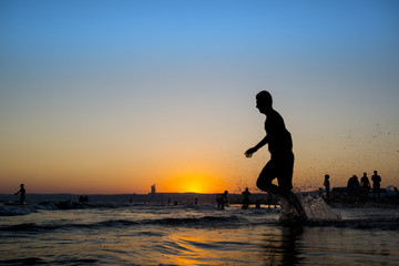 Naklejka na ściany i meble Man running on the beach at sunset