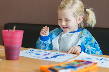 kleines Mädchen malt mit Wasserfarben